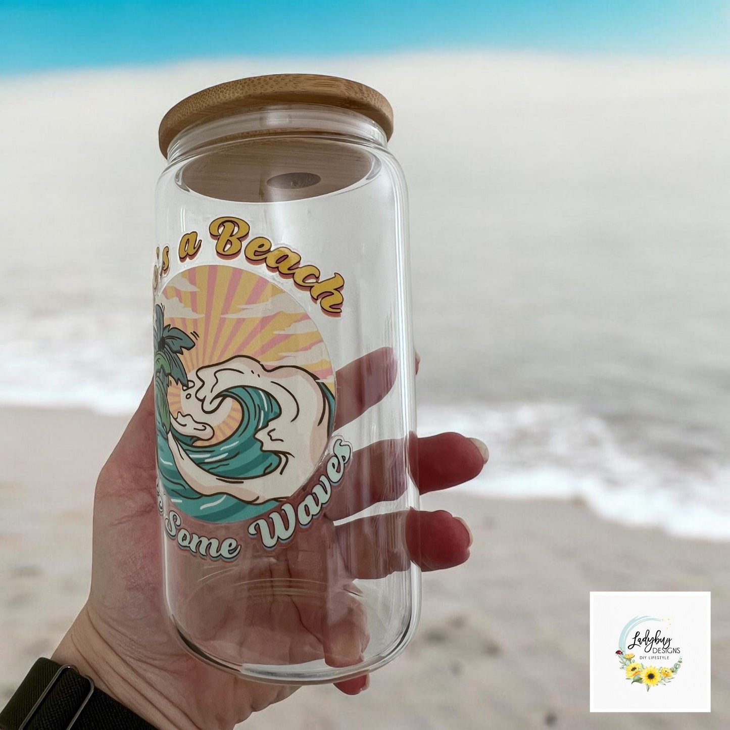 Life&#39;s a Beach Make Some Waves Cup with bamboo lid and plastic straw. Features a 16 oz beer can glass design with permanent UV DTF transfer. Perfect for iced coffee and summer vibes. Ideal as a funny and sarcastic gift, hand wash care instructions.