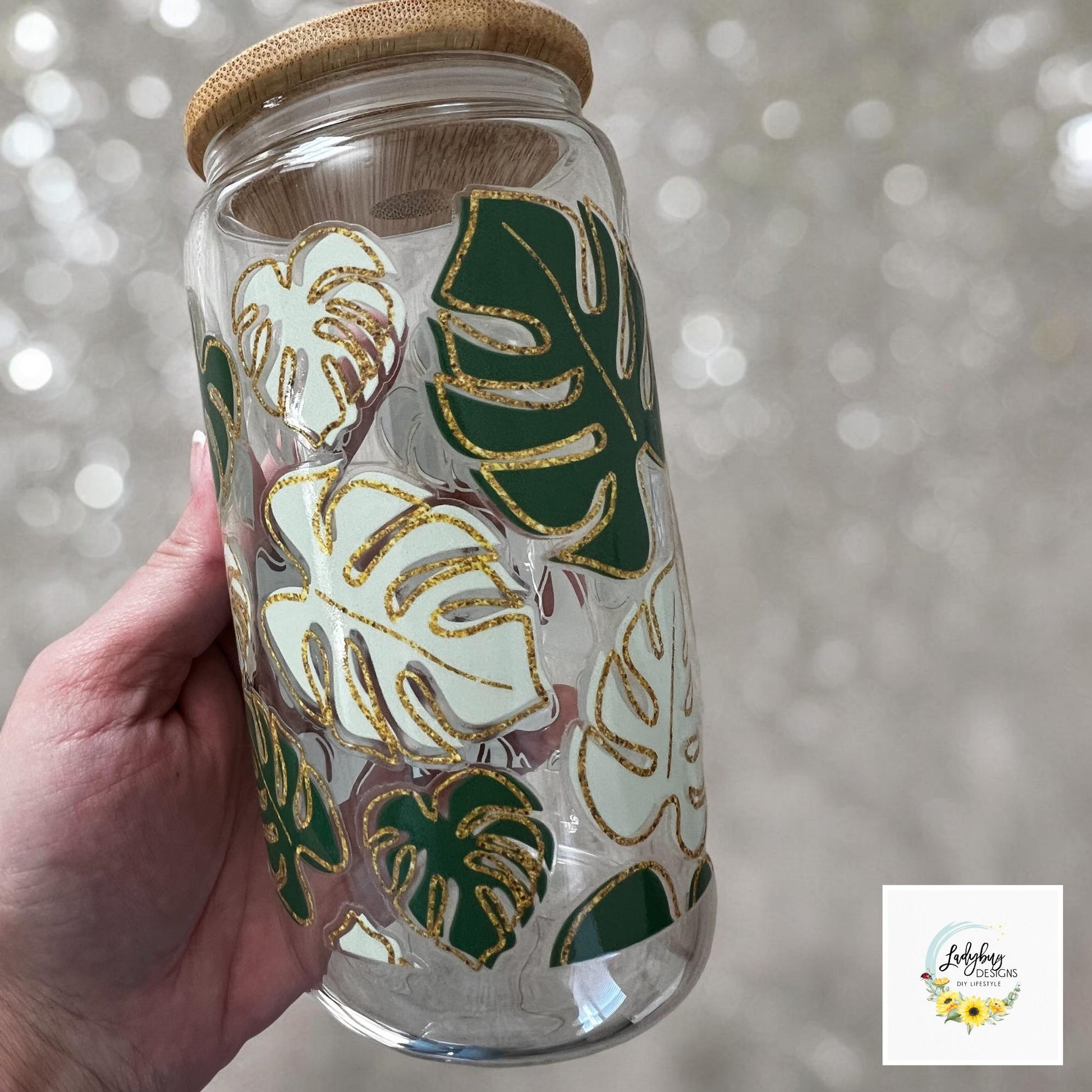 Monstera Leaf Cup with bamboo lid and plastic straw. Features a 16 oz beer can glass design with permanent UV DTF transfer. Perfect for iced coffee and plant lovers. Ideal as a plant mom gift, with hand wash care instructions.