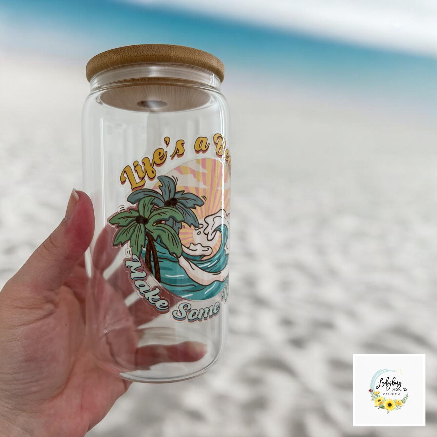 Life&#39;s a Beach Make Some Waves Cup with bamboo lid and plastic straw. Features a 16 oz beer can glass design with permanent UV DTF transfer. Perfect for iced coffee and summer vibes. Ideal as a funny and sarcastic gift, hand wash care instructions.