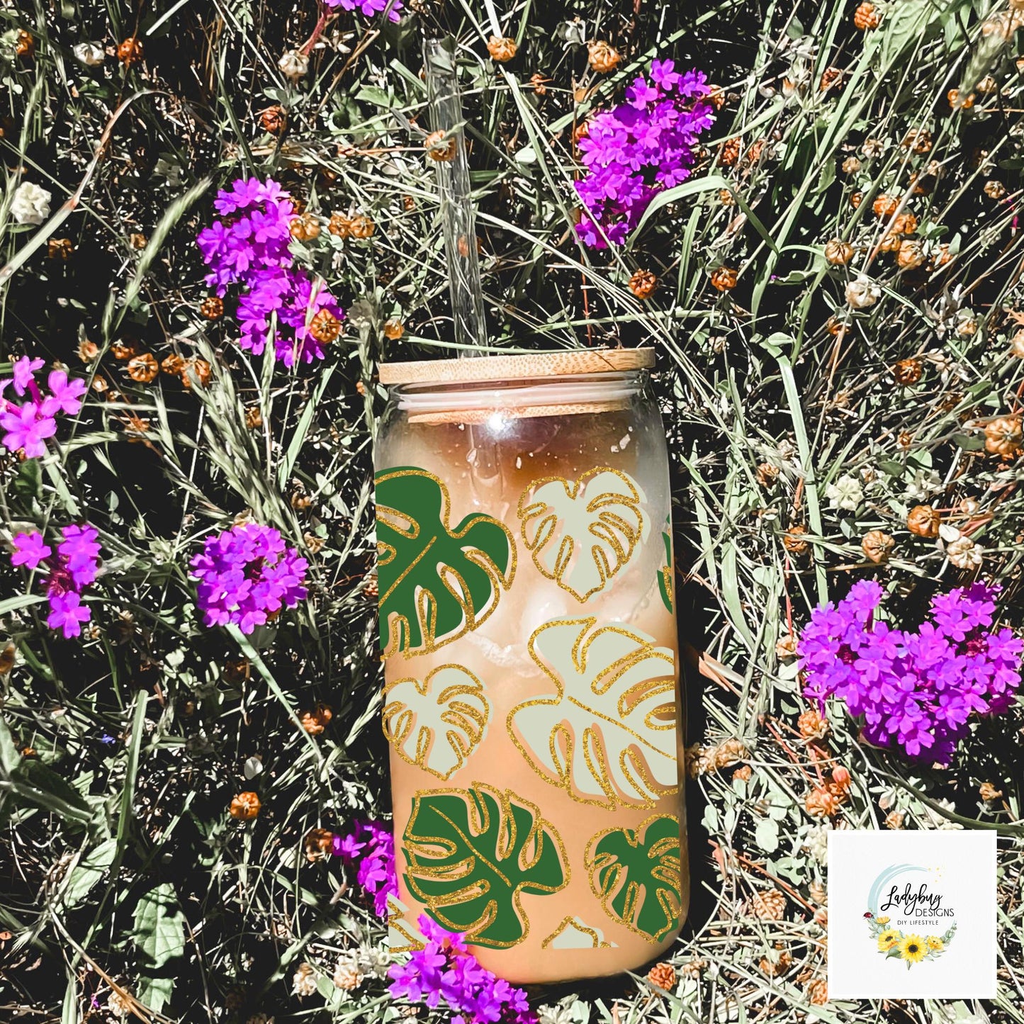 Monstera Leaf Cup with bamboo lid and plastic straw. Features a 16 oz beer can glass design with permanent UV DTF transfer. Perfect for iced coffee and plant lovers. Ideal as a plant mom gift, with hand wash care instructions.