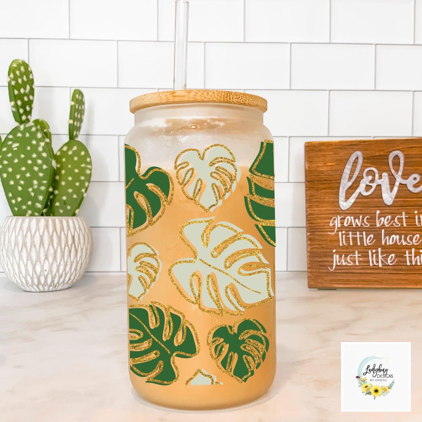 Monstera Leaf Cup with bamboo lid and plastic straw. Features a 16 oz beer can glass design with permanent UV DTF transfer. Perfect for iced coffee and plant lovers. Ideal as a plant mom gift, with hand wash care instructions.