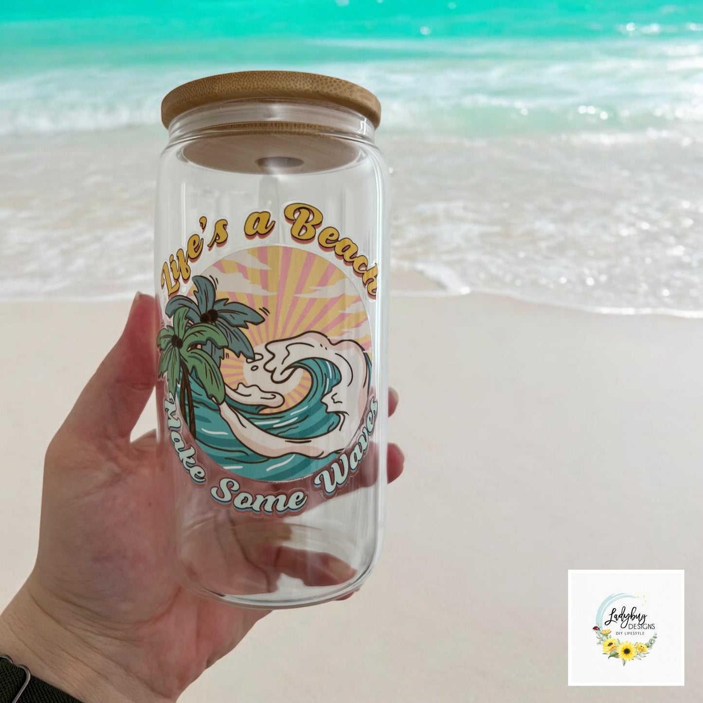 Life&#39;s a Beach Make Some Waves Cup with bamboo lid and plastic straw. Features a 16 oz beer can glass design with permanent UV DTF transfer. Perfect for iced coffee and summer vibes. Ideal as a funny and sarcastic gift, hand wash care instructions.